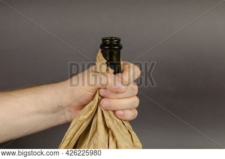 Social Problem Of Alcoholism Concept. Shaking Hand Holds An Open Bottle Of Alcohol In Paper Bag. Dar