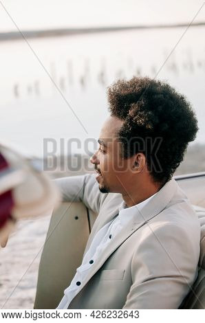 Young African American Man Groom In A Convertible Car At Sunset In Nature.