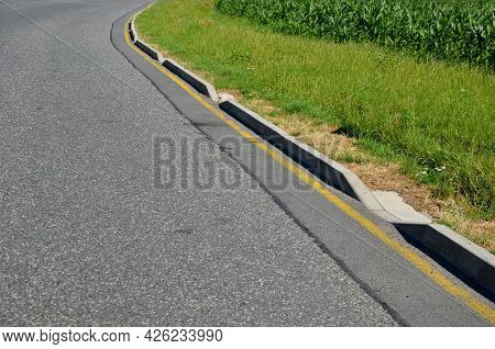 Installation Of Concrete Curbs With Gaps That Let Water Into The Park Into The Ditch, Where It Seeps