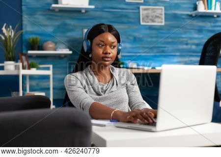 African American Student Wearing Headphones During Education Webinar Remote Working At Communication