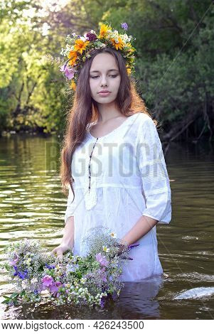 Ivan's Day. A Girl In White Robes Is Throwing A Wreath Down The River. Vertical Portrait.