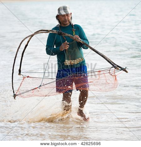 Homem Local nativo de redes no mar, Tailândia