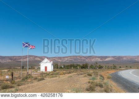 Matjiesfontein, South Africa - April 20, 2021: British Flags And A Building Next To The Entrance Roa