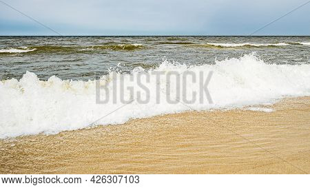 Sea Waves On The Beach And Overcast Sky
