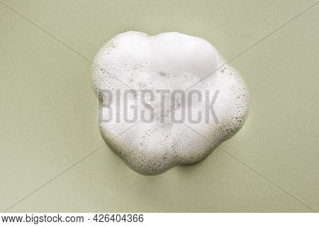 Face Cleansing Mousse Sample. White Cleanser Foam Bubbles On Green Background. Soap, Shower Gel, Sha