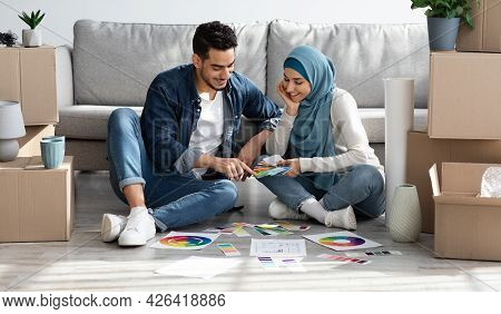 Excited Arab Couple Working On Design For New Apartment