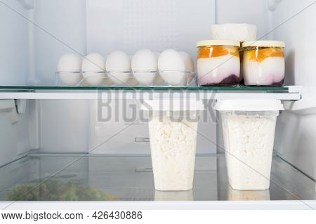 Cottage Cheese And Yoghurts With Egg Are On The Shelf In Refrigerators, Front View Close-up