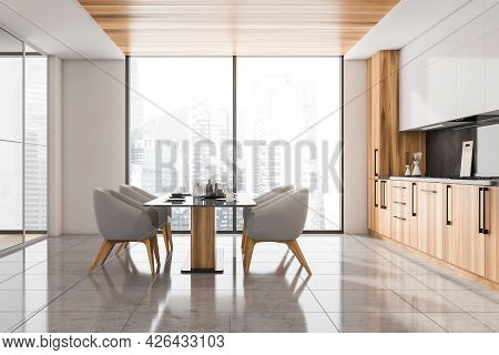 Side View Of The Kitchen Interior With Grey Chairs. Panoramic Windows. Half White Wooden Cabinet Wit