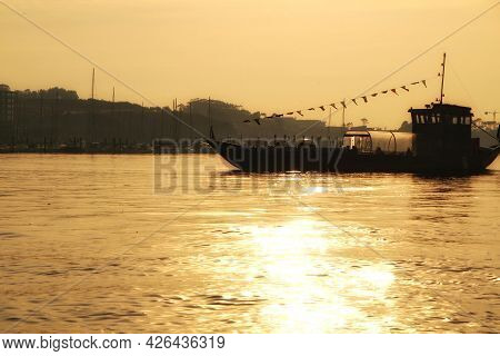 Typical Portuguese Boats Called Rabelos Crossing The Douro River In Porto At Sunset