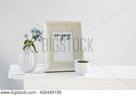 Flower Hackelia Velutina In A White Fluted Vase In The Style Of The Seventies, A Photo Frame With Th