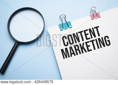 Magnifying Glass Loupe With Sign Content Marketing On The Paper Notepad Wtih Colored Paper Clips On
