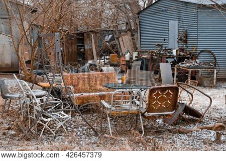 A Yard In Winter Cluttered With Discarded Junk And Trash