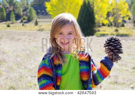Enfant little pine tenue de fille à cône en hiver tombent au plein air de la nature