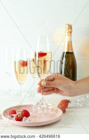 Female Hand Holds Delicious Rossini Cocktail On White Wooden Background