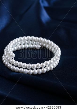 Pearl Armband på en blå sidentyg