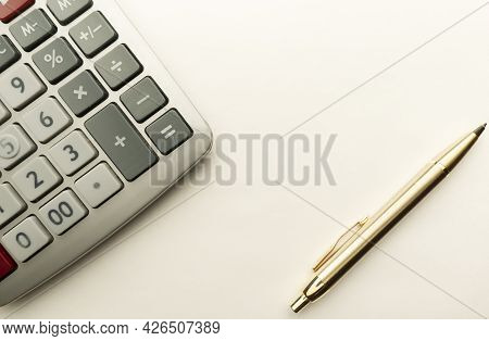 Calculator And Ballpoint Pen Close-up On A Light Background.
