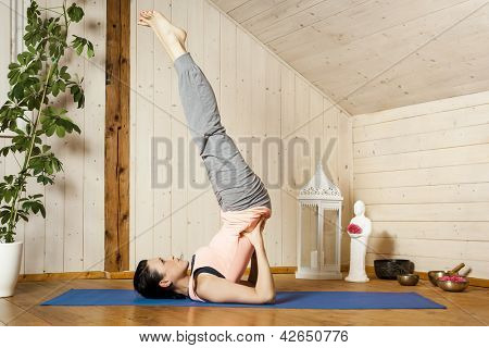 Obrázek hezké ženy dělá jógu doma - Salamba Sarvangasana