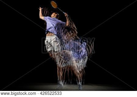 One Young Male Badminton Player, Shuttler Training Isolated On Dark Background. Stroboscope Effect.