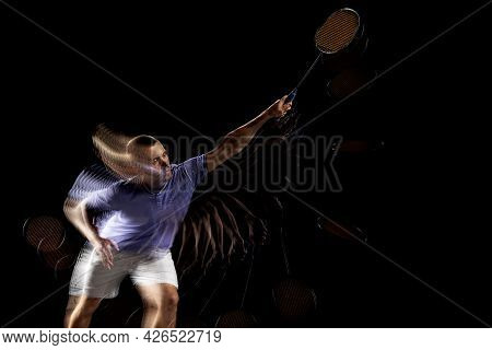 One Young Male Badminton Player, Shuttler Training Isolated On Dark Background. Stroboscope Effect.