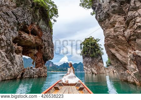 Young Female Tourist In Dress And Hat At Longtail Boat Near Famous Three Rocks With Limestone Cliffs