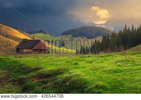 Breathtaking Alpine Countryside Place With Green Fields And High Misty Piatra Craiului Mountains At 