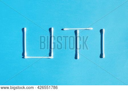 The Word Urinary Tract Infection Uti Is Lined With Cotton Sticks On A Blue Background