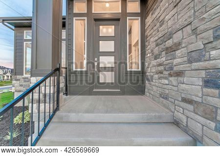 Front View Of The House Entrance With Glass Panelled Front Door And Sidelights