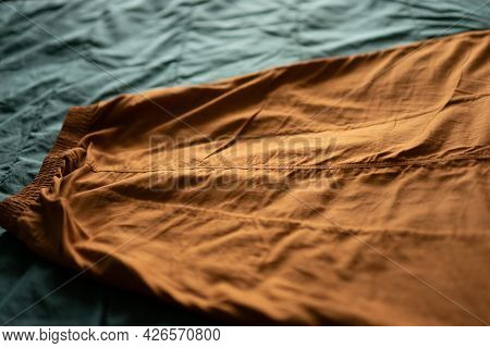 A Wrinkled Brick Midi Skirt Ies On A Green Fabric