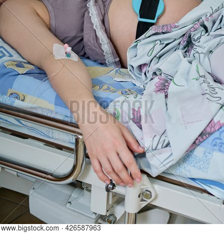 A Pregnant Woman Gives Birth In A Hospital With A Drip And A Ctg Machine. Woman On Clinic Bed With A