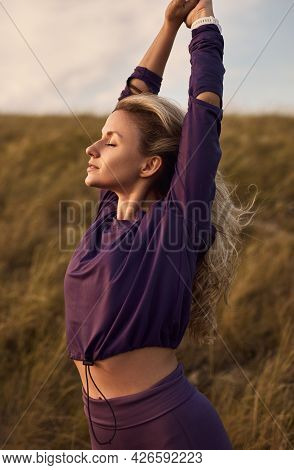 Peaceful Young Fit Female In Sportswear Stretching Arms And Enjoying Freedom And Seclusion While Res
