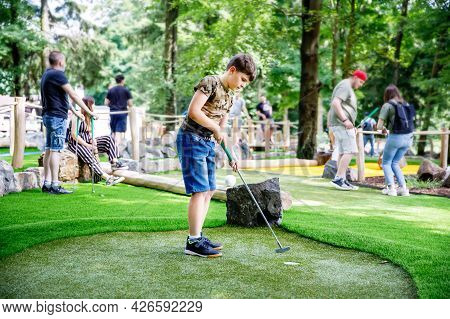 School Kid Boy Playing Mini Golf With Family. Happy Child Having Fun With Outdoor Activity. Summer S