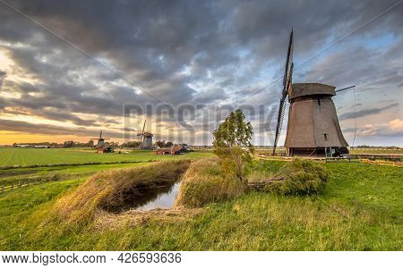 Three Traditional Wooden Windmills In Old Agricultural Landscape Near Schermerhorn, North Holland. N