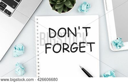 Text Dont Forget On Notebook. Laptop, Pieces Of Paper, Pen And Plant On Office Desk. Flat Lay, Top V