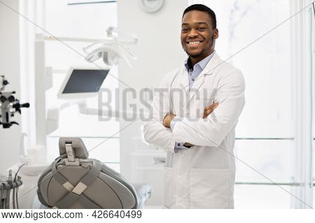Portrait Of Smiling Black Stomatologist Doctor Wearing Uniform Posing In Clinic