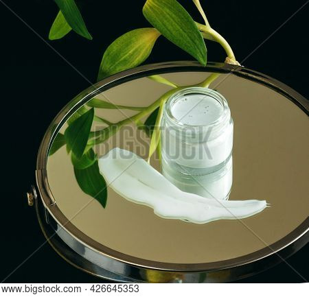 Korean Skin Cream In A Small Glass Container With Textured Smear On Mirror Podium. Moisturizing Skin