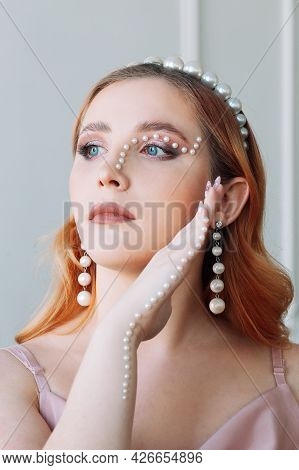 Close-up Portrait Of A Red-haired Young Woman With Makeup Made Of Pearls In The Form Of A Zigzag Or 