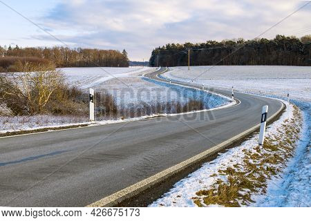 Country Road With Delineators  In Winter Landscape In Hesse, Germany