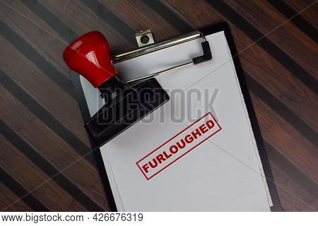 Red Handle Rubber Stamper And Furloughed Text Isolated On White Background.