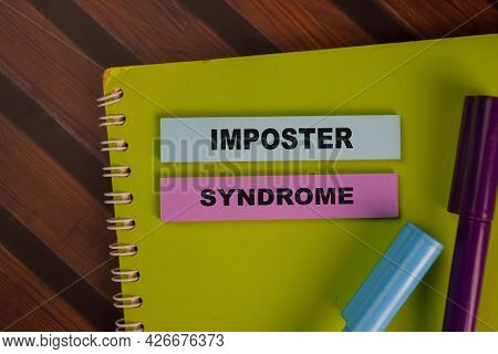 Imposter Syndrome Write On Sticky Notes Isolated On Wooden Table.