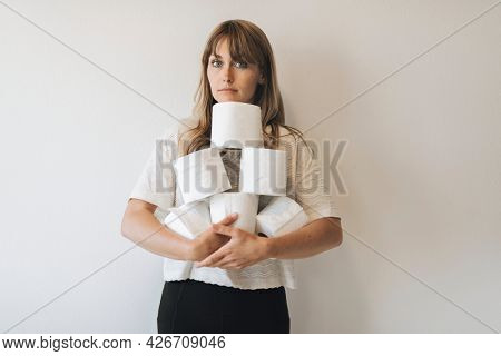 Woman with a pile of toilet tissue rolls