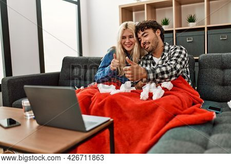 Young ill couple having medical teleconsultation using laptop at home.