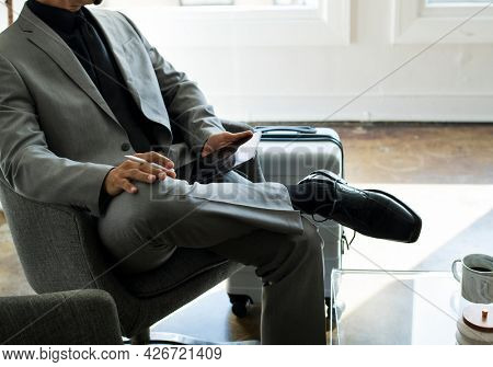 Businessman using a stylus with his digital tablet in an airport lounge