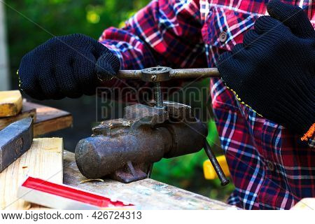 A Man Cuts A Thread On A Bolt, Which Is Clamped In A Vice. Grandpa Works In The Backyard. Dyi
