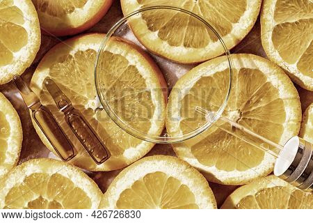 Glass Petri Dish With Transparent Pure Serum For Skin Care With Ampulas Over Natural Orange Slices, 