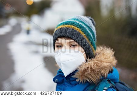 Kid Boy Wearing Ffp Medical Mask On The Way To School. Child Backpack Satchel. Schoolkid On Cold Aut
