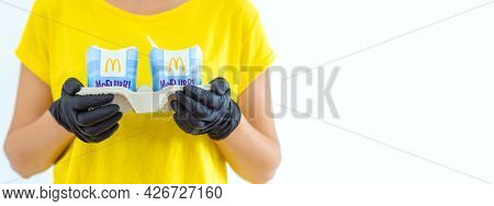 Woman In A Yellow T-short Holding An Ice Cream Mcflurry In Medical Gloves. Delivery Mccafe. Fast Foo