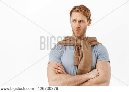 Displeased Redhead Man Frowning, Cross Arms On Chest Reluctant And Looking Left At Copyspace With Cr