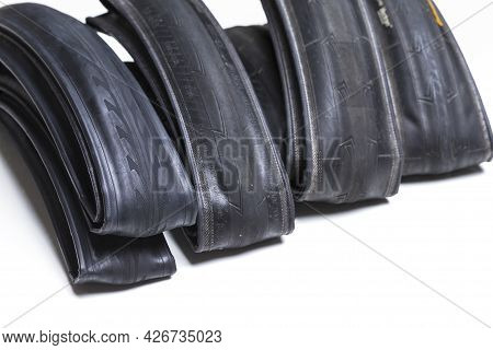 Closeup Image Of Set Of Four Different Road Bike Folded Tyres Placed Together Over White Background.