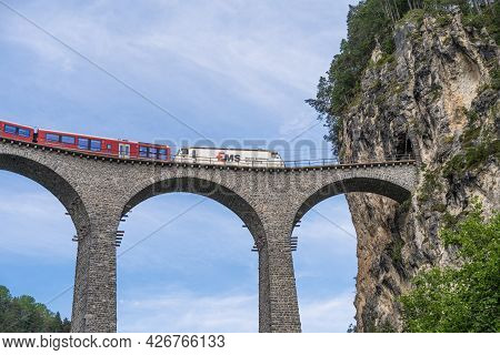 Filisur, Switzerland - June 17, 2021: A Train Is Crossing A Famous Landwasser Viaduct Nearby Filisur