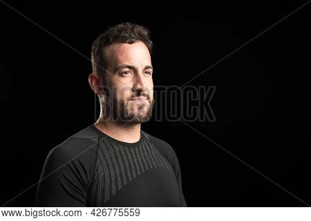 Portrait Of An Adult Male Standing Looking To The Side On Black Background